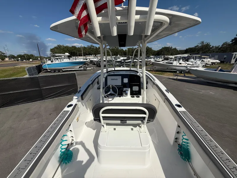Slide: The Image of 2022 Aquasport 2300 Center Console boat with American flag, docked in marina. - 35