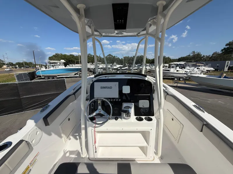 Slide: The Image of 2022 Aquasport 2300 Center Console boat with steering wheel and navigation equipment. - 40