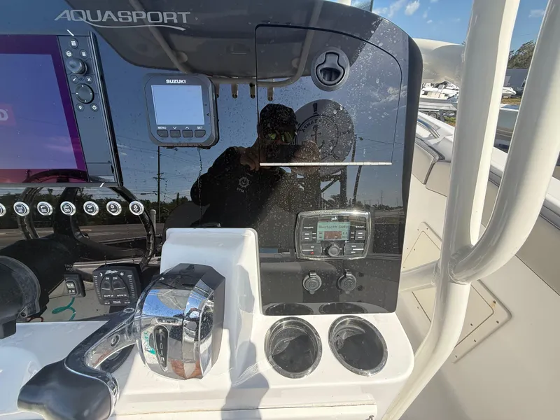 Slide: The Image of 2022 Aquasport 2300 Center Console dashboard with controls and electronics. - 45