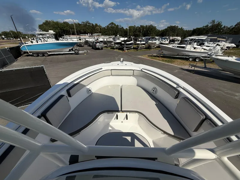 Slide: The Image of 2022 Aquasport 2300 Center Console boat, docked with other vessels under a clear sky. - 48