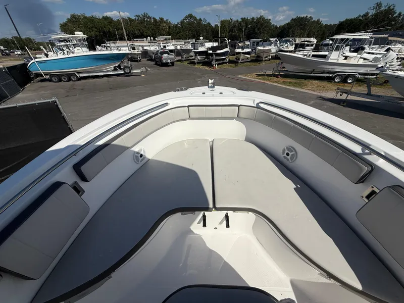 Slide: The Image of 2022 Aquasport 2300 Center Console boat interior with seating, docked among other boats. - 49