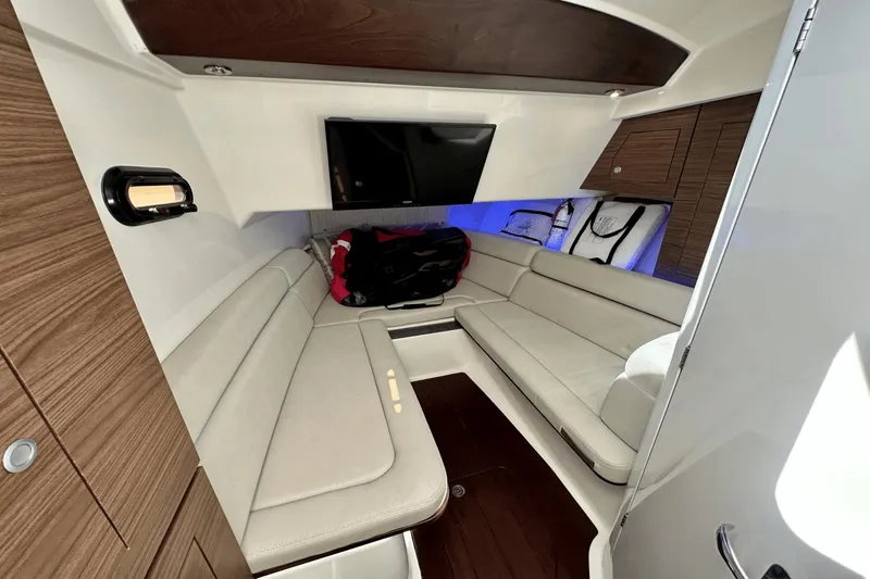 Slide: The Image of 2019 Boston Whaler 350 Realm cabin interior with seating and TV. - 11