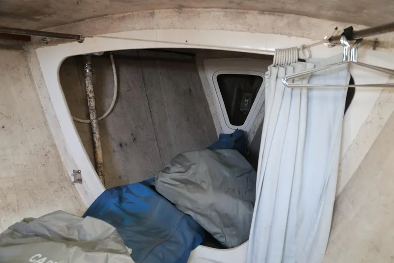 Slide: The Image of Interior cabin of a 1992 Catalina Capri 37 sailboat with storage and curtain. - 9