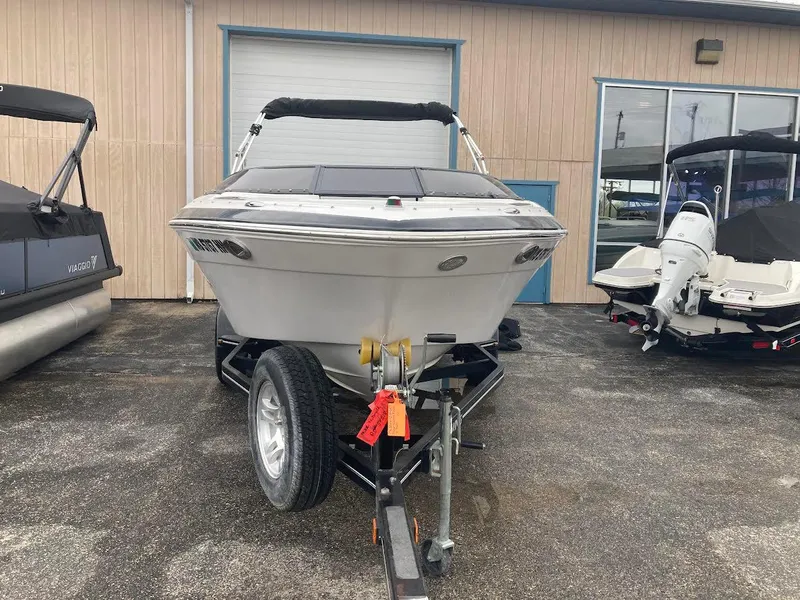 Slide: The Image of 2008 Four Winns H200 boat on trailer, parked outdoors near other boats. - 2