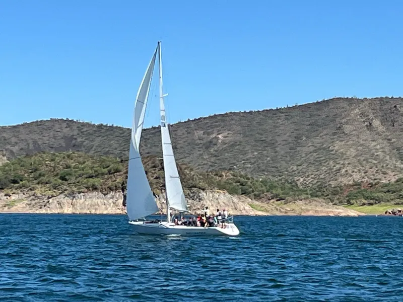 Slide: The Image of Sailboat Catalina Capri 37, 1992 model, gliding on a lake with scenic hills in the background. - 4