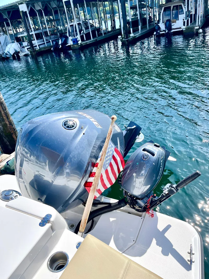 Slide: The Image of 2018 Ranger Tugs R-27 boat with outboard motor and American flag at marina. - 14