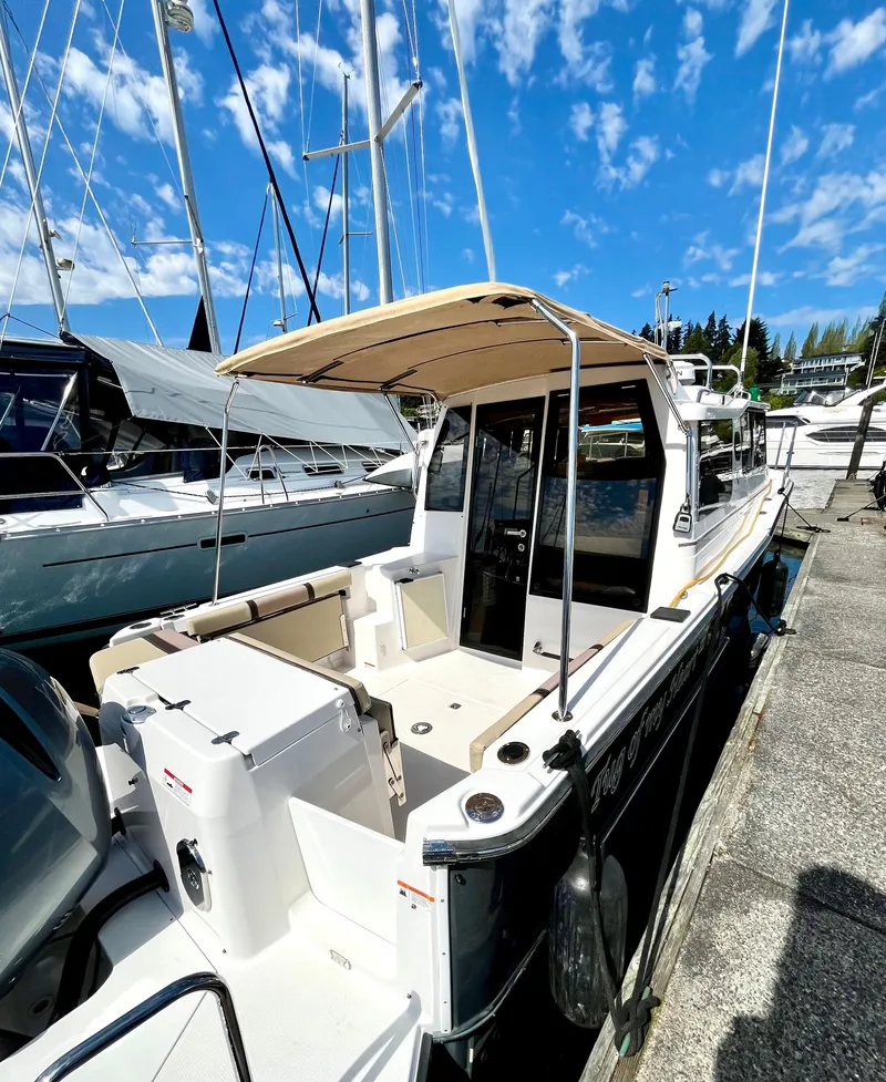 Slide: The Image of 2018 Ranger Tugs R-27 boat docked under a clear blue sky. - 2