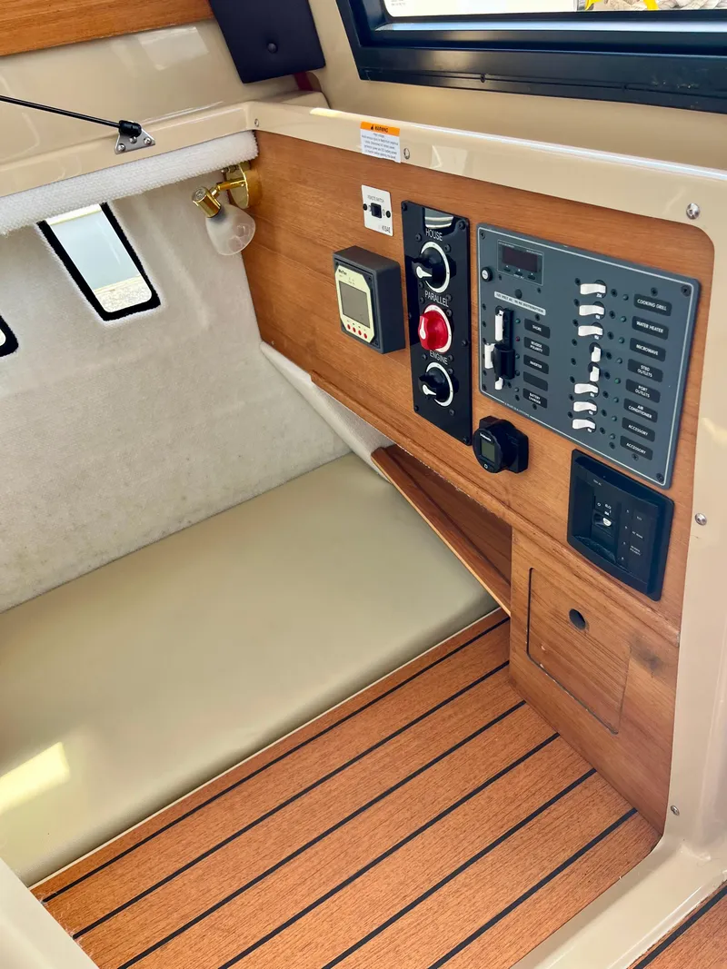 Slide: The Image of 2018 Ranger Tugs R-27 cabin interior with control panel and wood accents. - 4