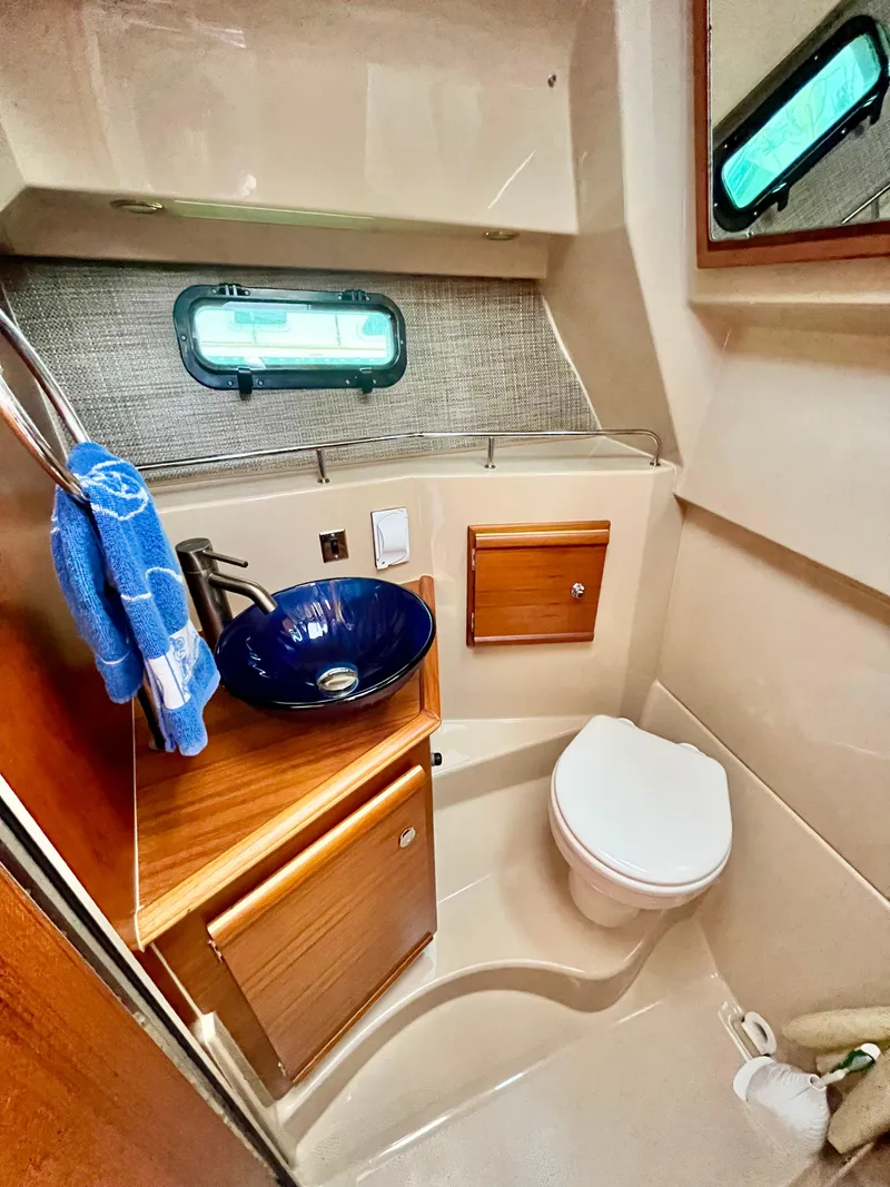 Slide: The Image of 2018 Ranger Tugs R-27 boat bathroom with sink, toilet, and window. - 9