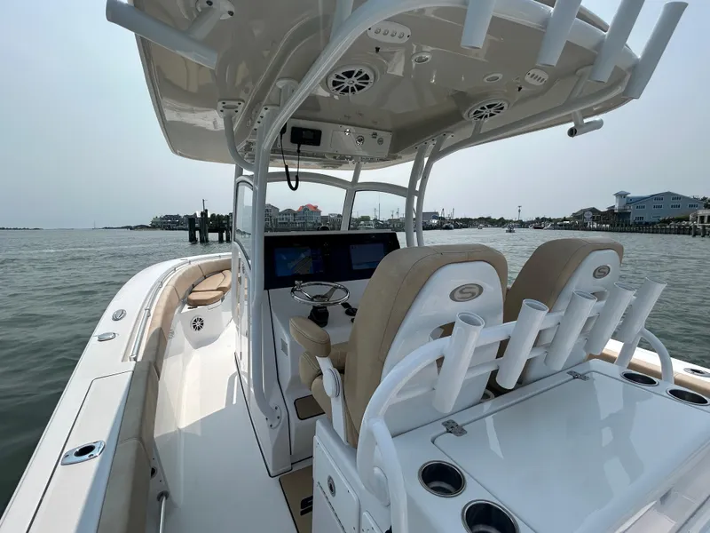 Slide: The Image of 2018 Sportsman Open 312 Center Console boat on water, featuring helm and seating area. - 13
