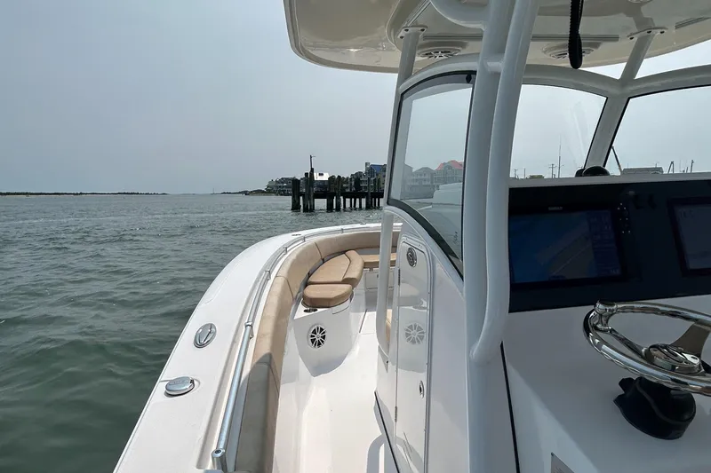 Slide: The Image of 2018 Sportsman Open 312 Center Console boat on calm waters near a dock. - 18