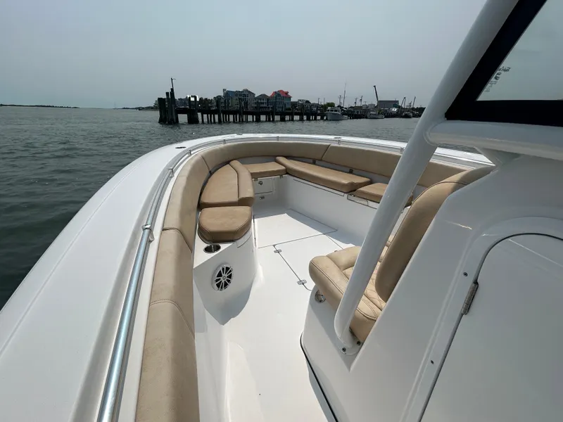 Slide: The Image of 2018 Sportsman Open 312 Center Console boat with beige seating, docked near a pier. - 19