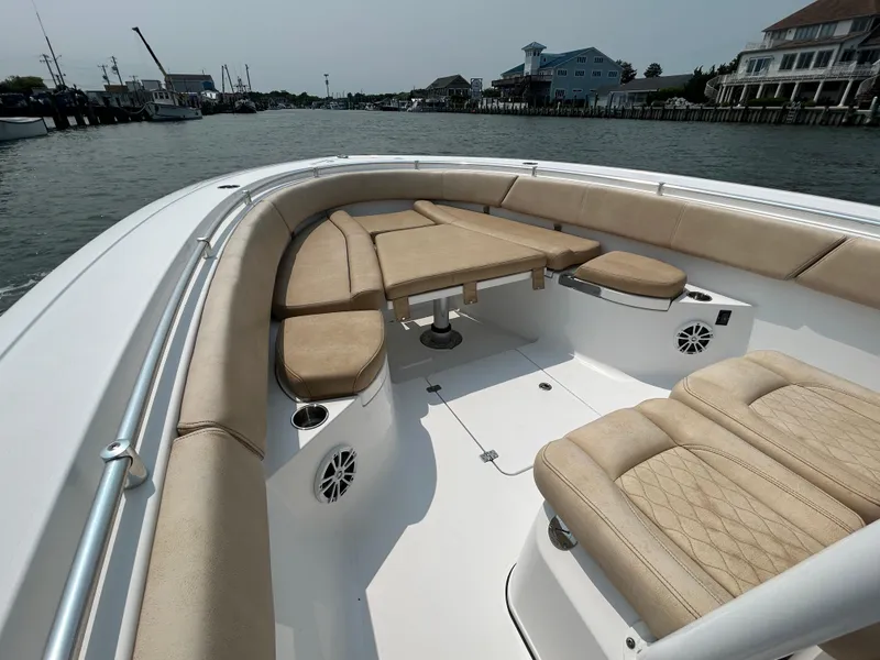 Slide: The Image of 2018 Sportsman Open 312 Center Console boat with beige seating, docked in a marina. - 20