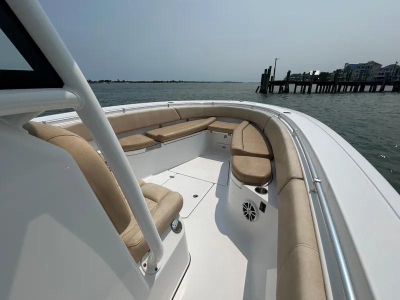 Slide: The Image of 2018 Sportsman Open 312 Center Console boat with spacious seating, docked near waterfront homes. - 23