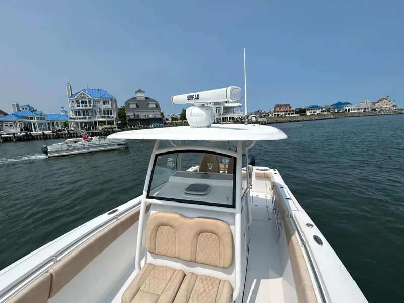Slide: The Image of 2018 Sportsman Open 312 Center Console boat on water near coastal buildings. - 24