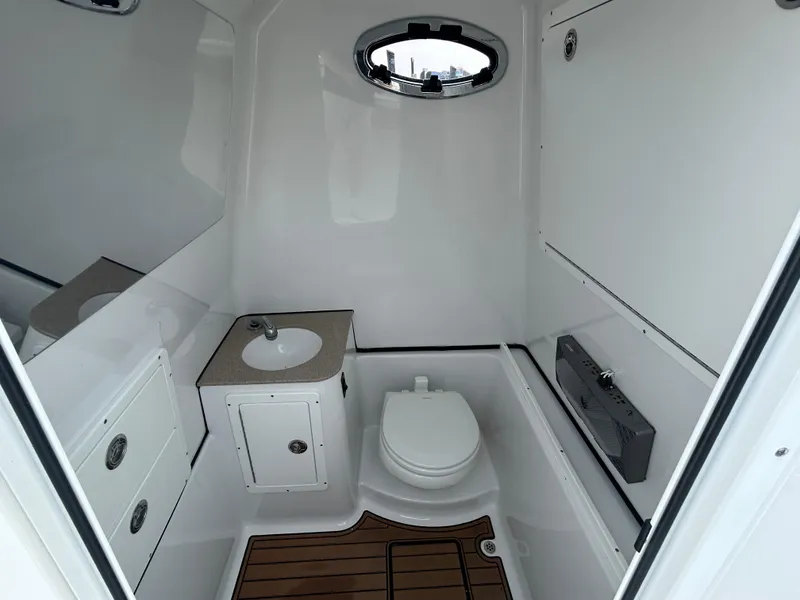 Slide: The Image of 2018 Sportsman Open 312 Center Console boat bathroom with sink, toilet, and wooden floor. - 26
