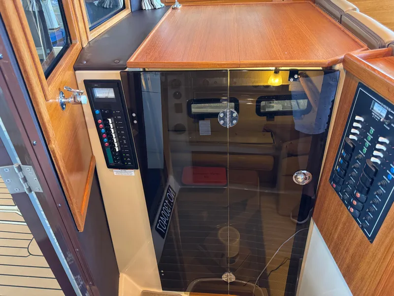 Slide: The Image of 2020 Ranger Tugs R-31 S cabin entrance with control panels and wooden finish. - 12