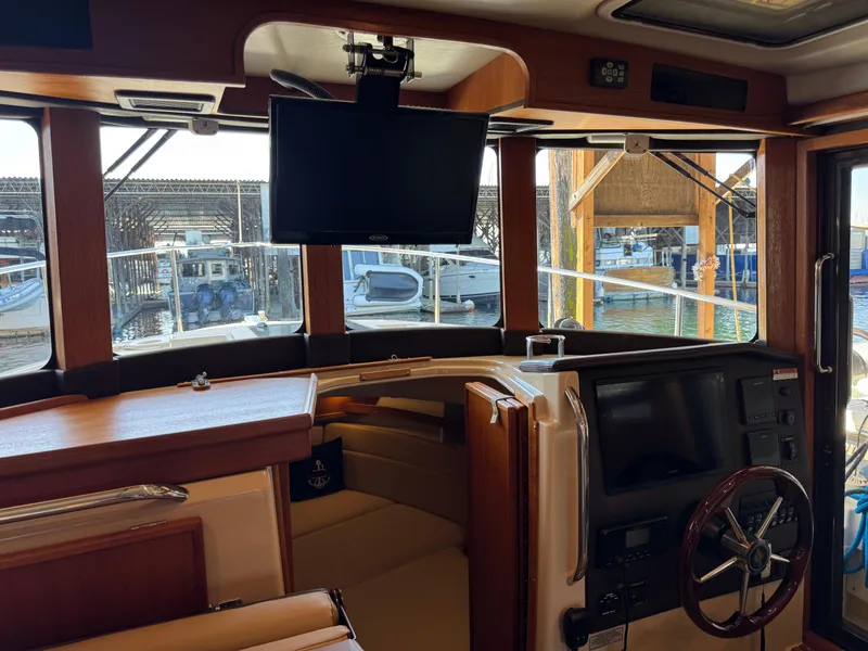 Slide: The Image of Interior of 2020 Ranger Tugs R-31 S boat with helm, TV, and marina view. - 18