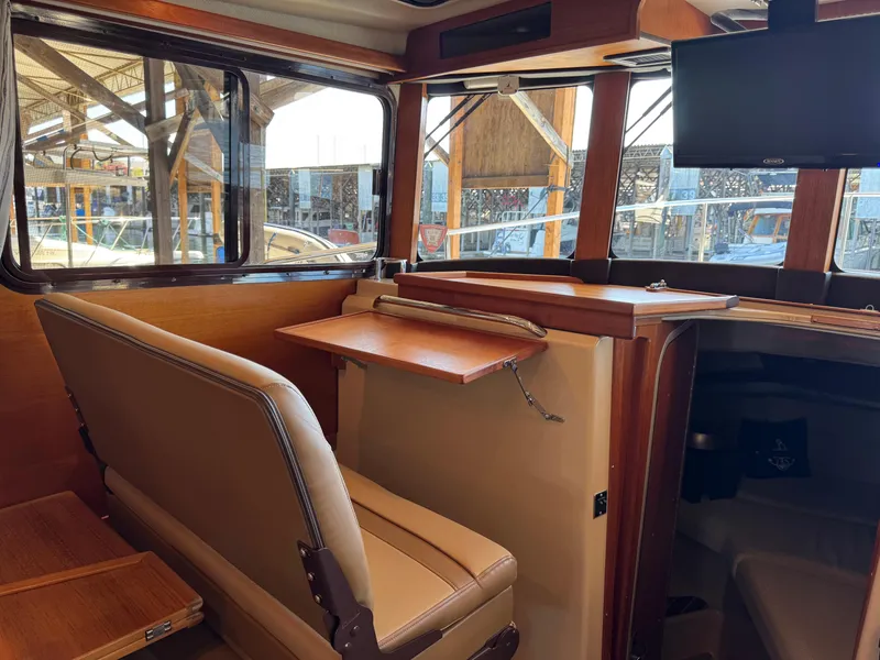 Slide: The Image of Interior of 2020 Ranger Tugs R-31 S with seating, table, and mounted TV. - 19