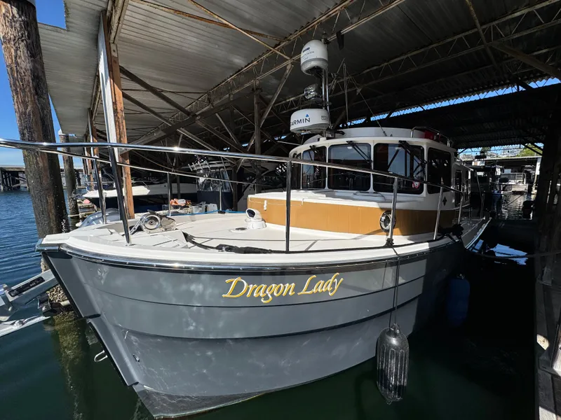 Slide: The Image of 2020 Ranger Tugs R-31 S boat named "Dragon Lady" docked in a covered marina. - 3