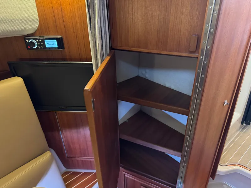 Slide: The Image of 2020 Ranger Tugs R-31 S interior with open wooden cabinet and TV. - 30