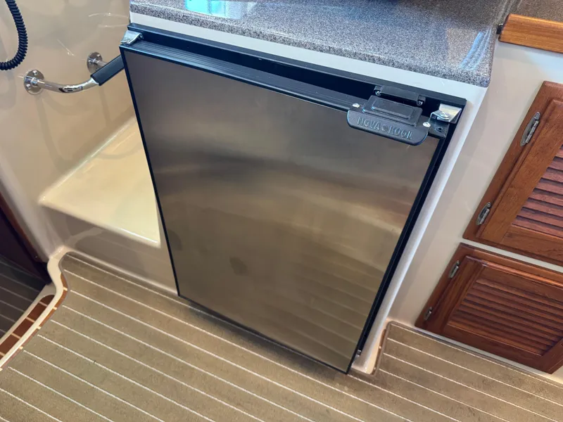 Slide: The Image of Stainless steel refrigerator in 2020 Ranger Tugs R-31 S boat interior, with wooden cabinetry. - 32