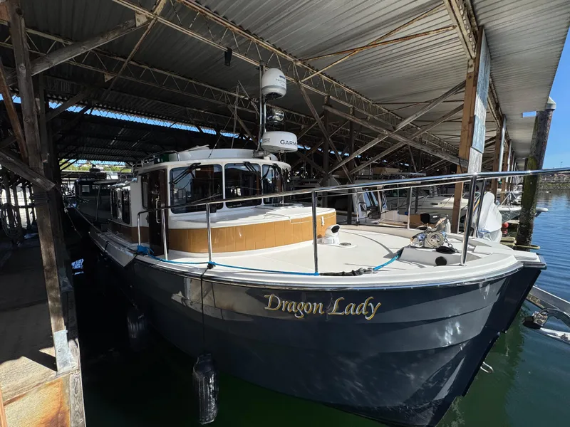 Slide: The Image of 2020 Ranger Tugs R-31 S boat named "Dragon Lady" docked in a covered marina. - 4