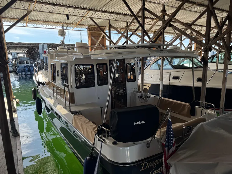 Slide: The Image of 2020 Ranger Tugs R-31 S docked in a covered marina, showcasing its sleek design. - 5