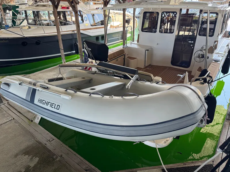 Slide: The Image of 2020 Ranger Tugs R-31 S with Highfield dinghy docked in a marina. - 6