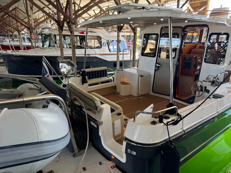 Slide: The Image of 2020 Ranger Tugs R-31 S boat docked in a marina, featuring spacious deck and cabin. - 7