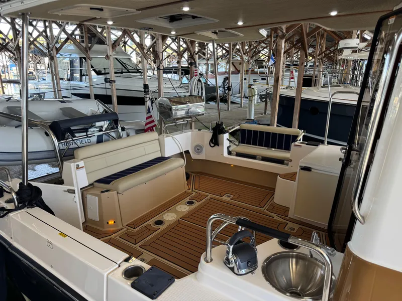 Slide: The Image of 2020 Ranger Tugs R-31 S boat interior with seating and sink, docked in a marina. - 8