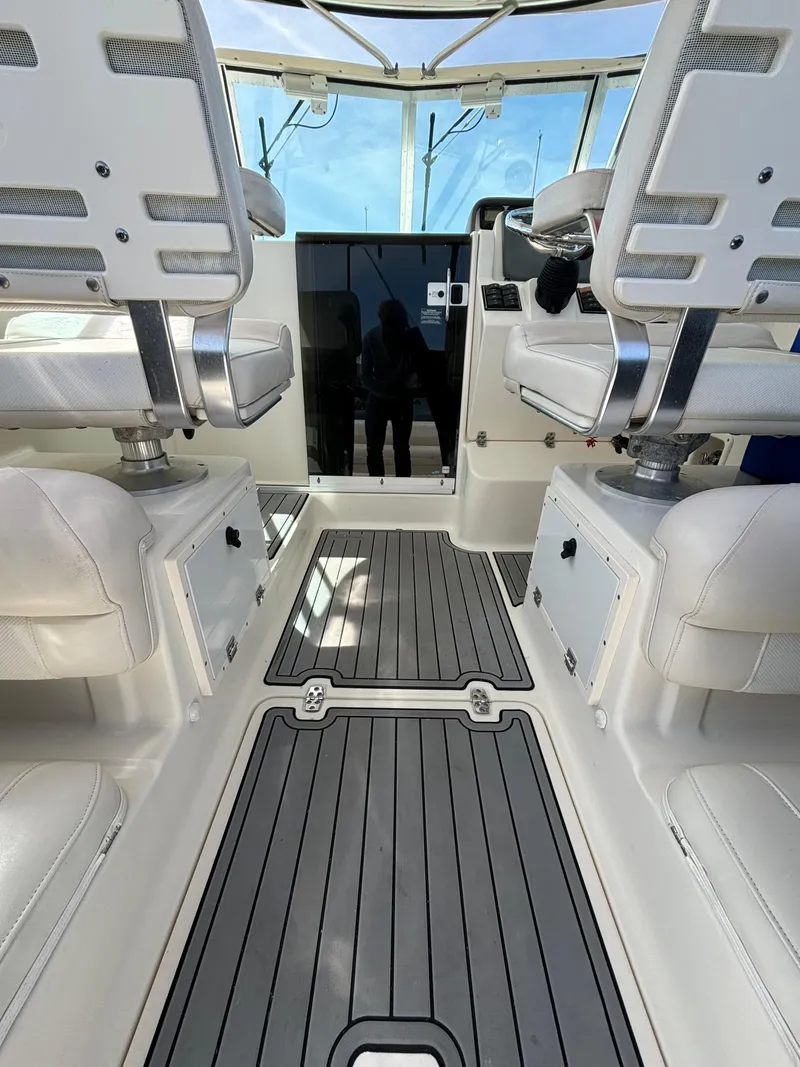 Slide: The Image of 2007 Pursuit 285 Offshore boat interior with cushioned seating and sleek flooring. - 10