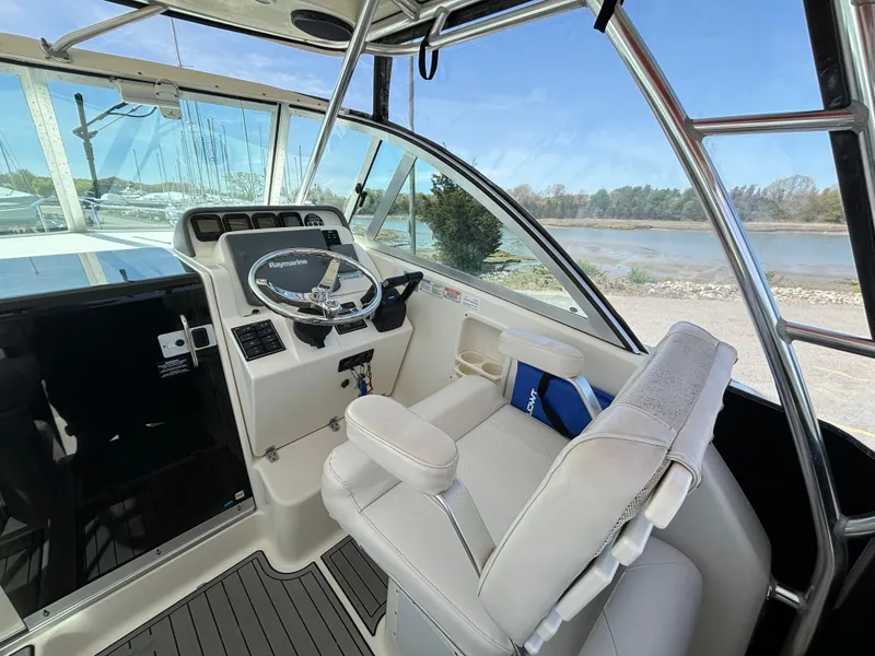 Slide: The Image of 2007 Pursuit 285 Offshore boat interior with steering wheel and captain's chair. - 12