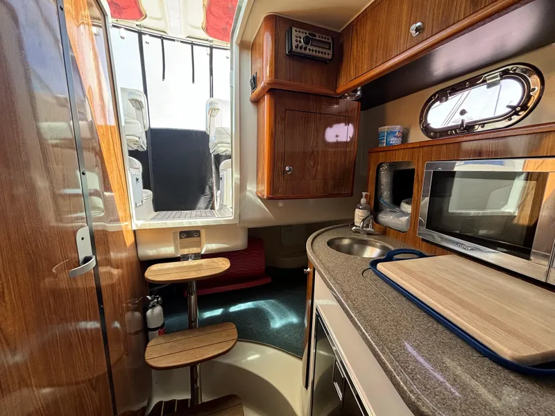 Slide: The Image of Interior of 2007 Pursuit 285 Offshore boat with kitchenette and wooden cabinetry. - 19