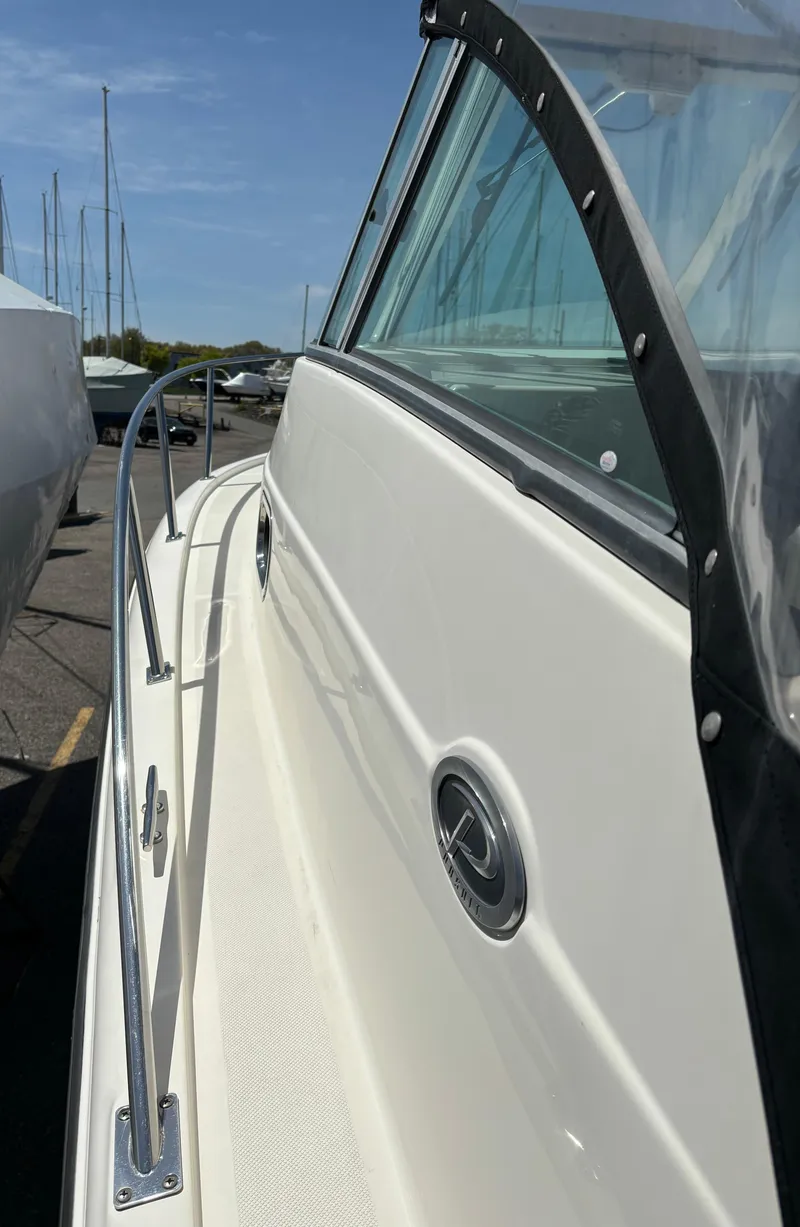 Slide: The Image of 2007 Pursuit 285 Offshore boat side view with railing and clear sky background. - 4