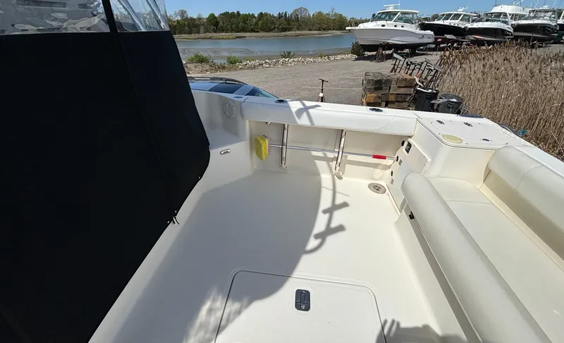 Slide: The Image of 2007 Pursuit 285 Offshore boat deck with seating, near a waterfront and docked boats. - 8