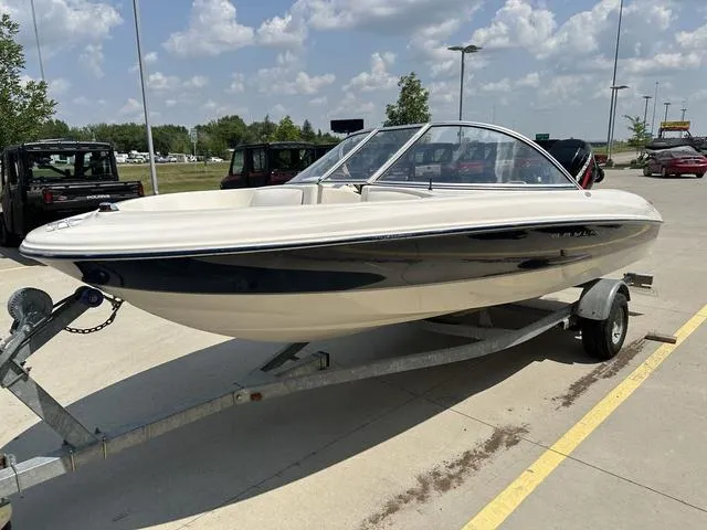 Slide: The Image of 2002 Bayliner 160 Capri boat on trailer under a sunny sky. - 13
