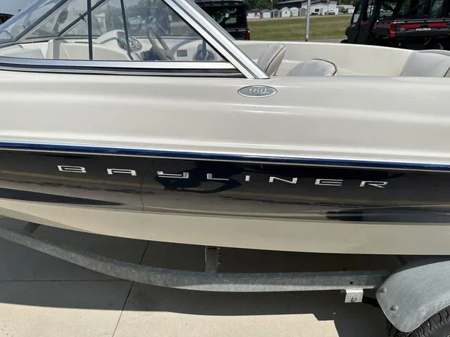 Slide: The Image of 2002 Bayliner 160 Capri boat side view on trailer, showcasing sleek design. - 15