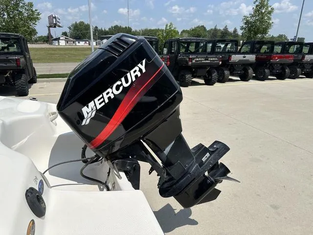 Slide: The Image of Outboard motor on a 2002 Bayliner 160 Capri boat, parked outdoors. - 16