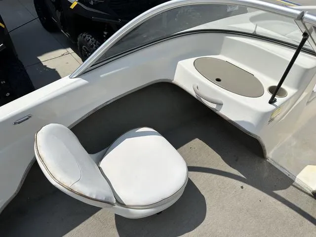 Slide: The Image of 2002 Bayliner 160 Capri boat interior with white seating and dashboard. - 24