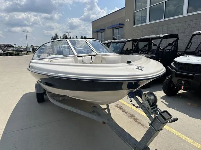Slide: The Image of 2002 Bayliner 160 Capri boat on trailer, parked outdoors near a building. - 3