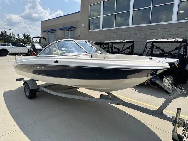 Slide: The Image of 2002 Bayliner 160 Capri boat on trailer, parked outside a building. - 4