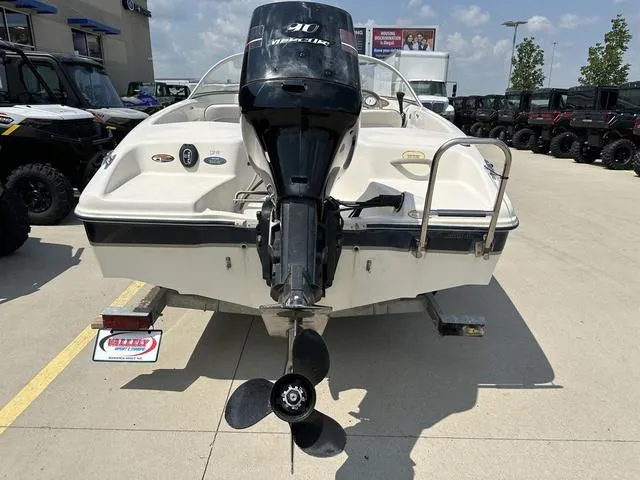 Slide: The Image of 2002 Bayliner 160 Capri boat with outboard motor, parked on a trailer. - 9