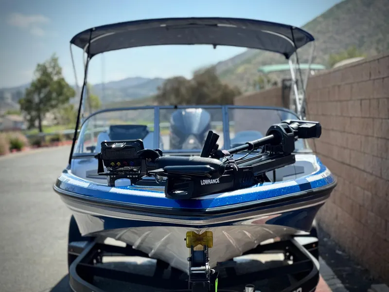 Slide: The Image of 2021 Nitro Z19 Sport boat with canopy, parked outdoors, featuring a Lowrance system. - 2
