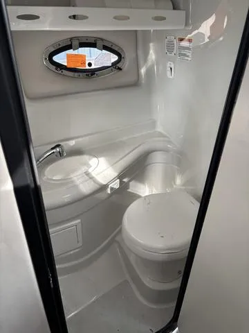 Slide: The Image of 2022 Crownline 264 CR boat bathroom with compact toilet and sink. - 7