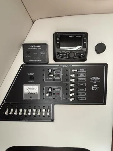 Slide: The Image of Control panel of a 2022 Crownline 264 CR boat with various switches and gauges. - 9