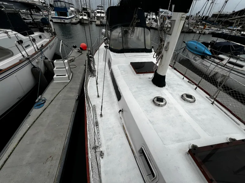 Slide: The Image of 1974 Irwin 37 Center Cockpit sailboat docked at marina, surrounded by other vessels. - 13