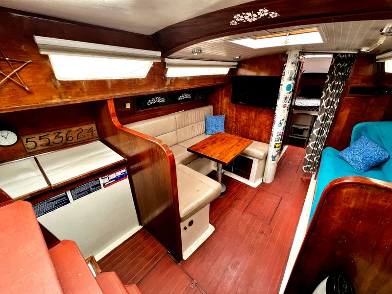Slide: The Image of 1974 Irwin 37 Center Cockpit interior with wood finish, seating area, and nautical decor. - 20