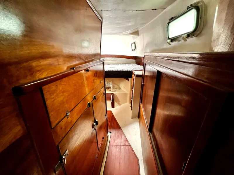 Slide: The Image of 1974 Irwin 37 Center Cockpit interior with wooden cabinetry and cozy sleeping area. - 24