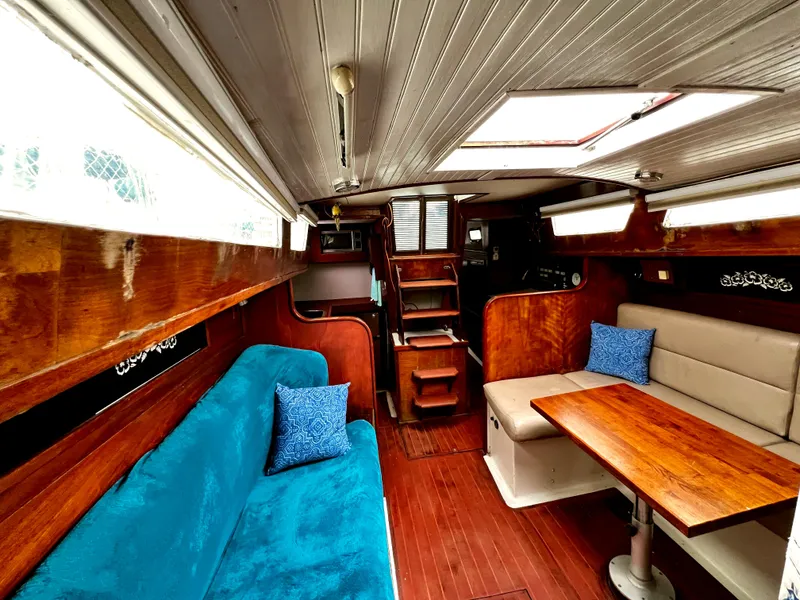 Slide: The Image of 1974 Irwin 37 Center Cockpit interior with wooden finish, blue and beige seating, and dining area. - 32